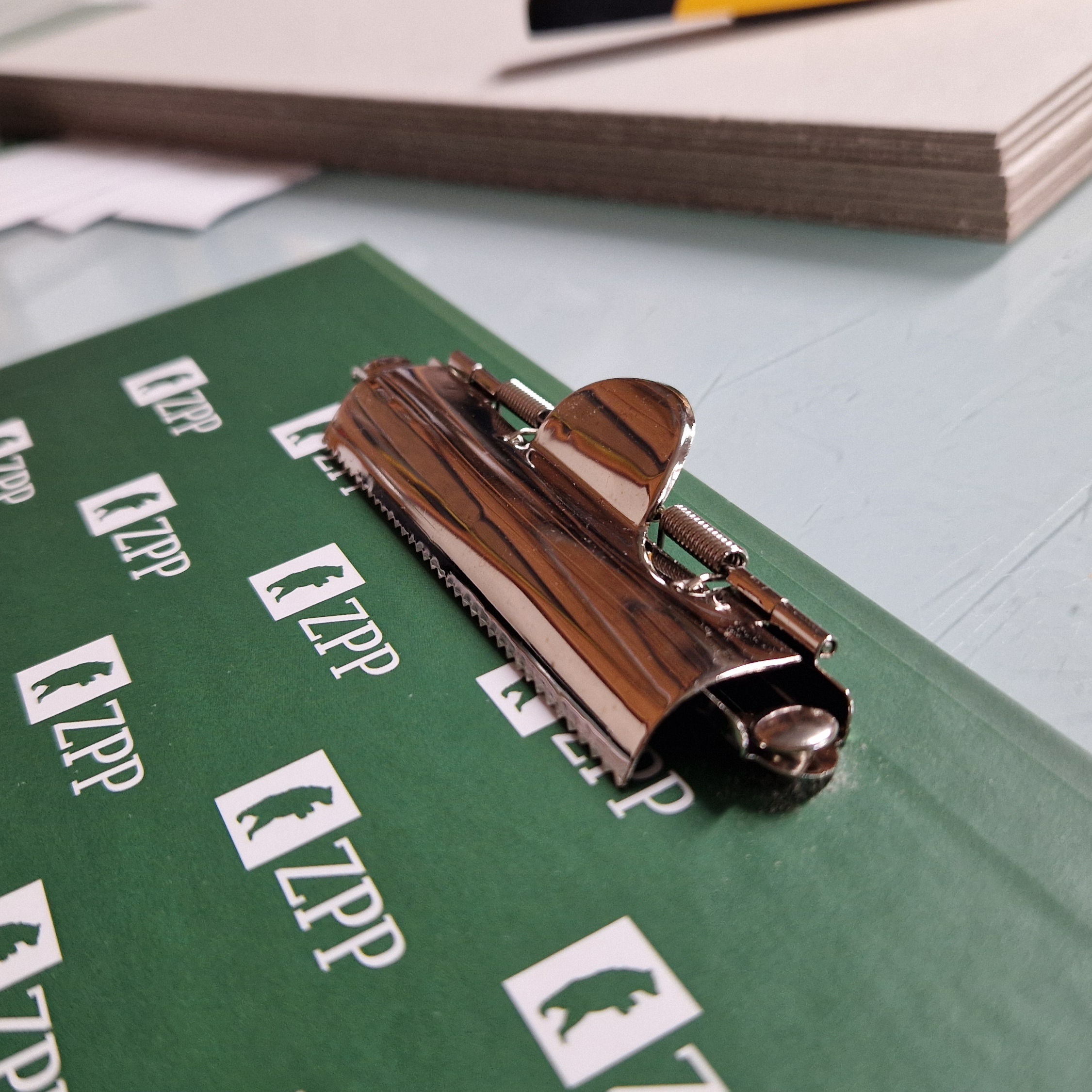 zielony clipboard zblizenie na mechanizm klipsa z ząbkami
